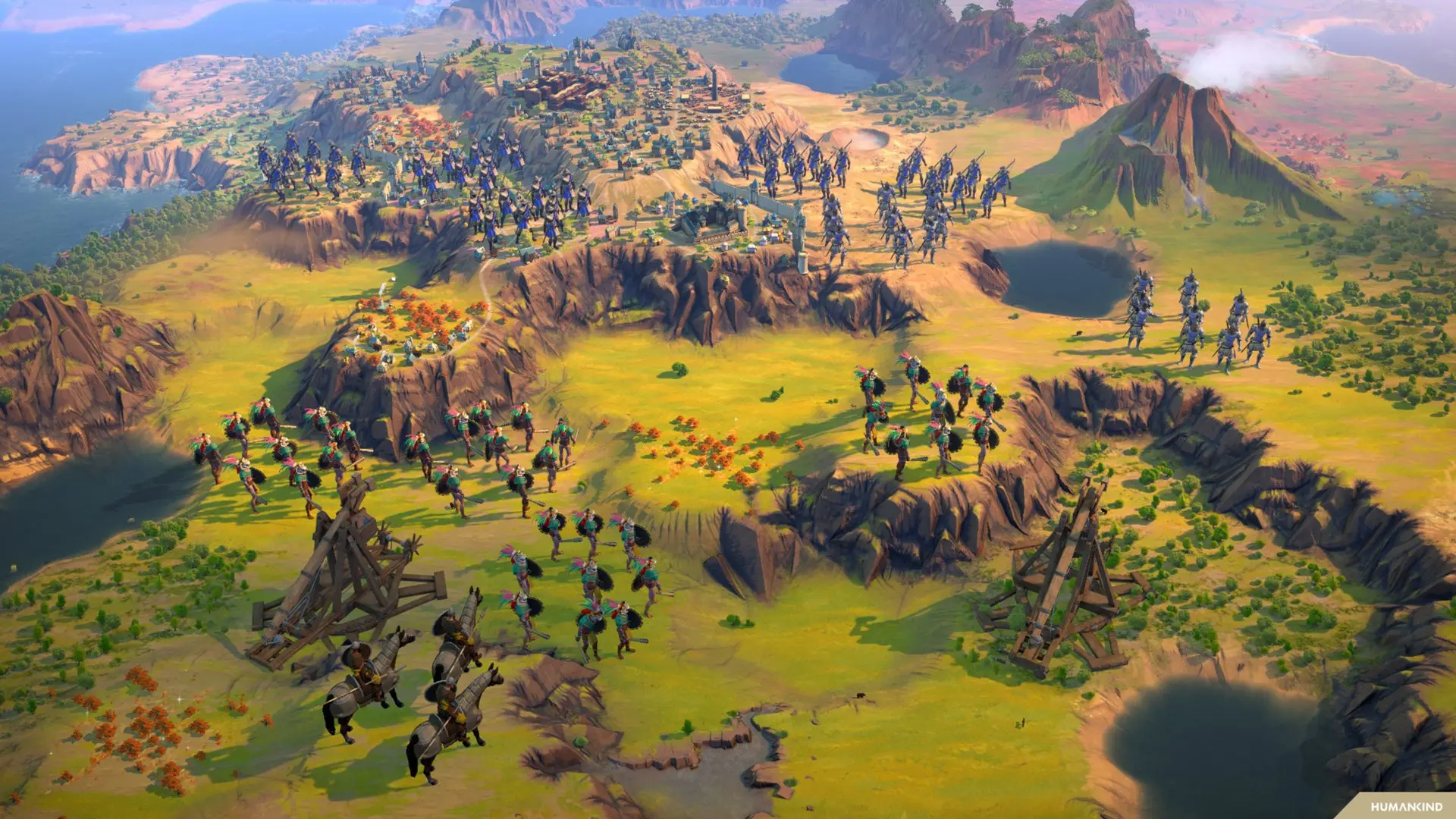 Aerial view of a Humankind game map showing armies, siege engines, and cities in a hilly landscape
