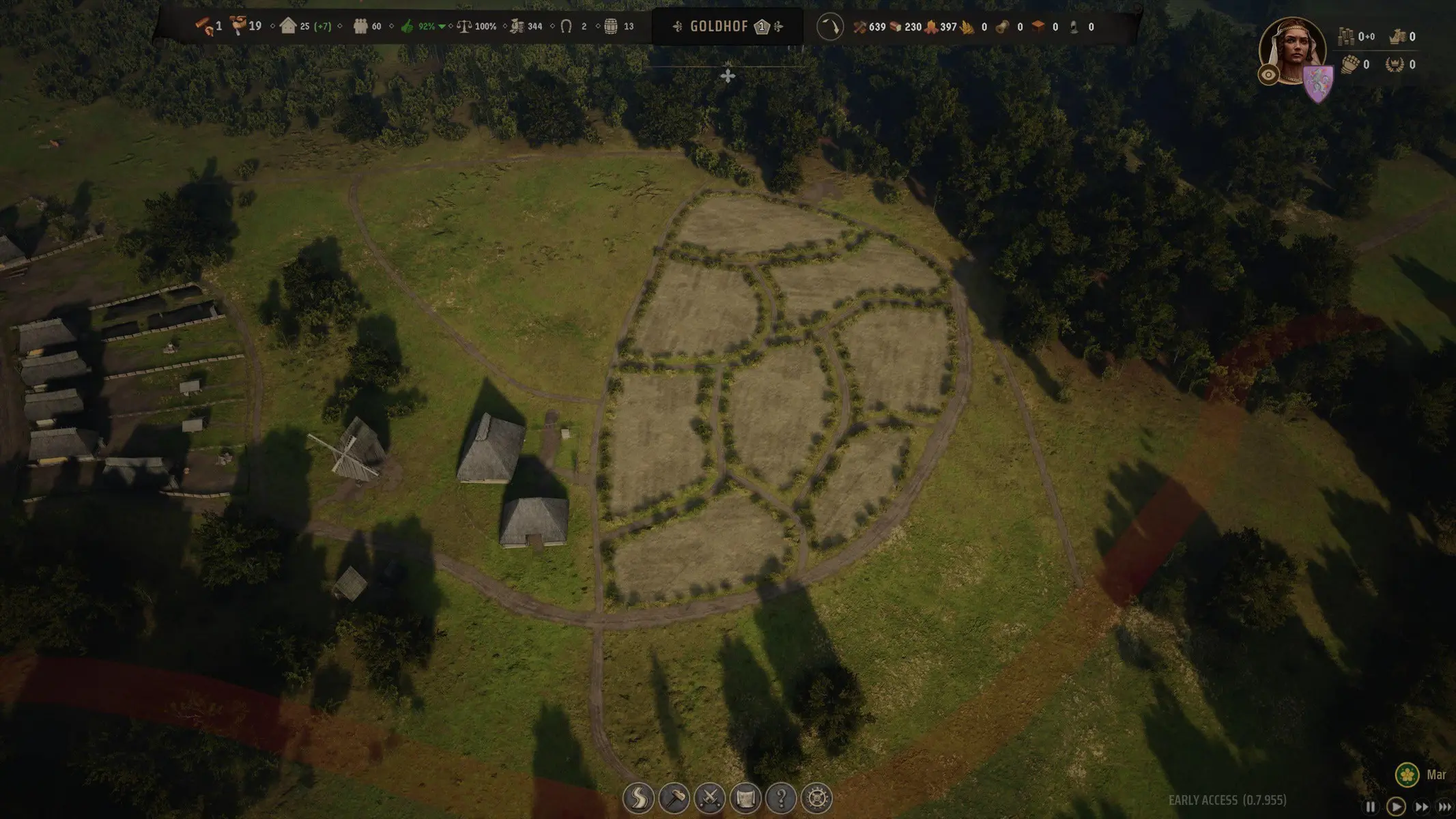 Aerial view of a medieval village in Manor Lords featuring cultivated crop fields and peasant houses