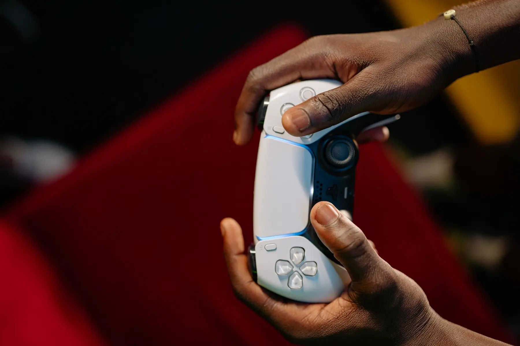 Close-up of a person's hands holding a white PlayStation 5 DualSense wireless controller